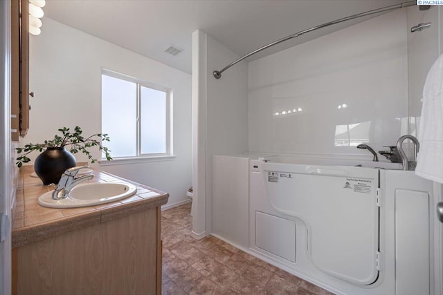 bathroom featuring baseboards, visible vents, vanity, and toilet