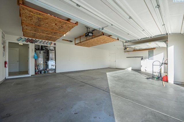 garage with water heater and a garage door opener