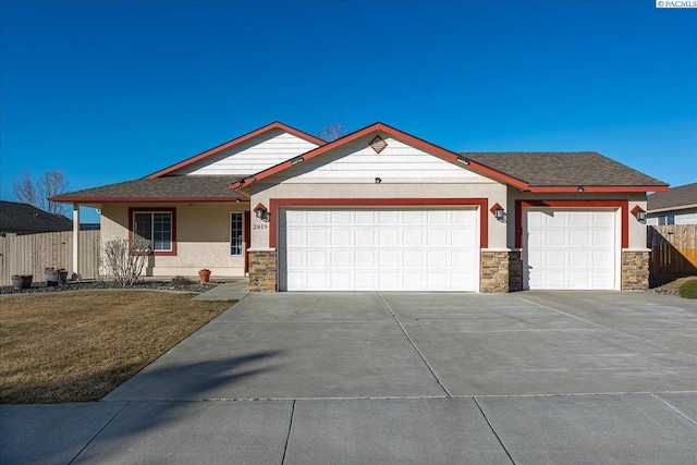 view of front of house featuring an attached garage, fence, and stucco siding