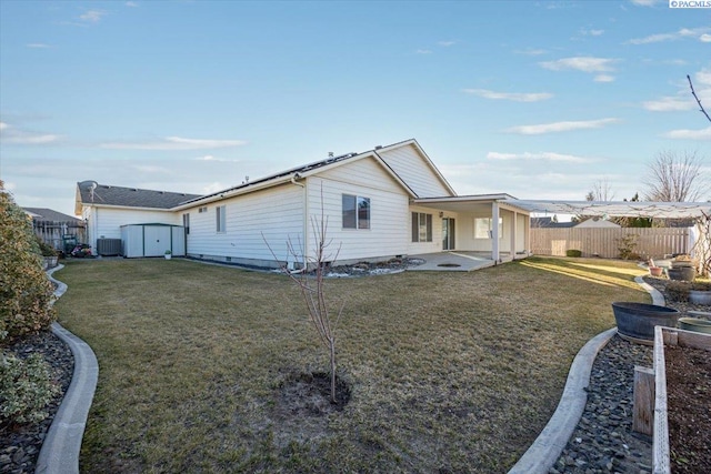 view of front of house with a front yard, central AC, a patio, and fence