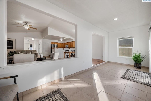 tiled living area with a ceiling fan, lofted ceiling, baseboards, and recessed lighting