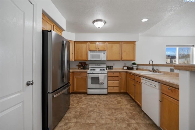 kitchen with tile counters, recessed lighting, a sink, a textured ceiling, and white appliances