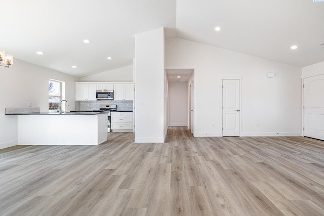 1613 Diamond Ave, Grandview, WA 98930 - unfurnished living room with vaulted ceiling, a sink, light wood-type flooring, baseboards, and recessed lighting