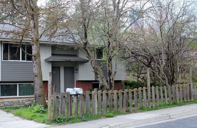 view of front facade with a fenced front yard and brick siding