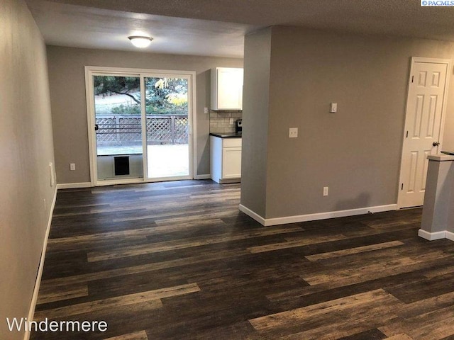 interior space with baseboards and dark wood-type flooring