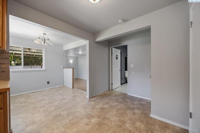 517 S Dawes St, Kennewick, WA 99336 - unfurnished room with stone finish floors, baseboards, and a chandelier