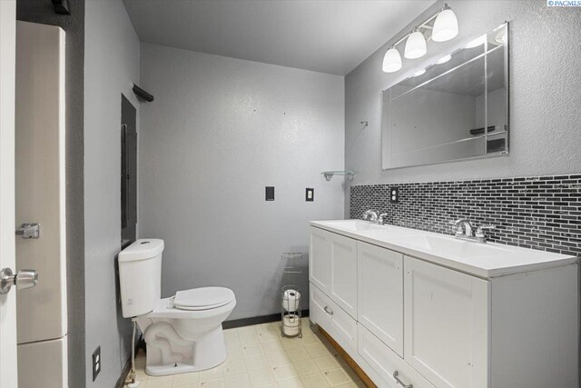 517 S Dawes St, Kennewick, WA 99336 - full bathroom featuring toilet, double vanity, backsplash, and tile patterned floors