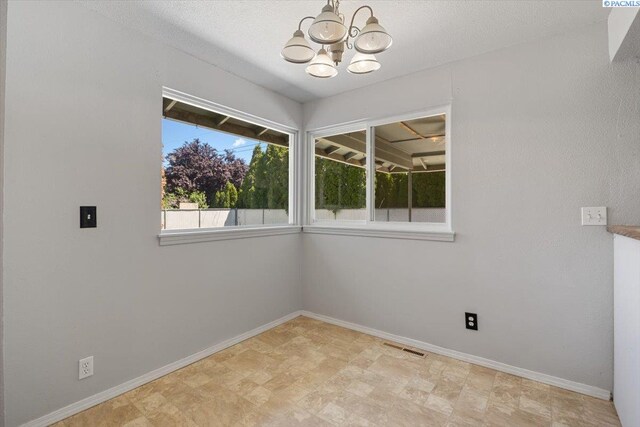 517 S Dawes St, Kennewick, WA 99336 - spare room featuring a chandelier, baseboards, and stone finish floors