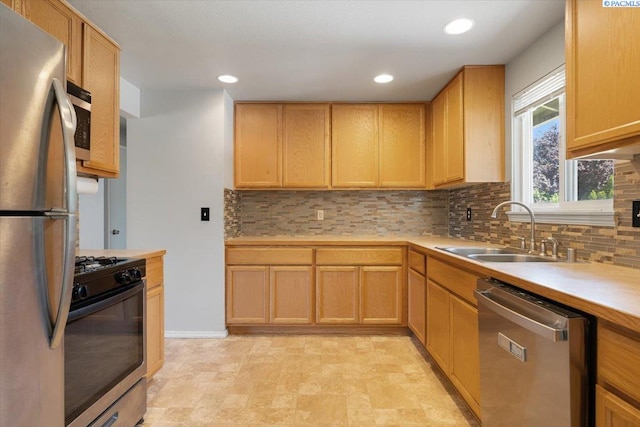517 S Dawes St, Kennewick, WA 99336 - kitchen featuring appliances with stainless steel finishes, a sink, decorative backsplash, light countertops, and recessed lighting