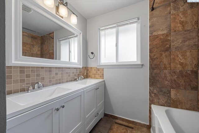 517 S Dawes St, Kennewick, WA 99336 - full bathroom featuring double vanity, backsplash, baseboards, and stone finish floors