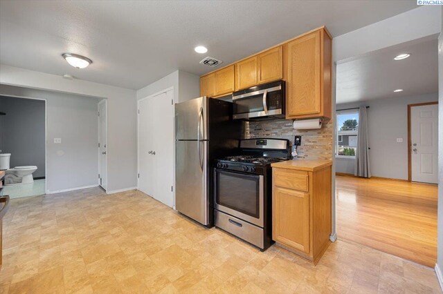 517 S Dawes St, Kennewick, WA 99336 - kitchen with stainless steel appliances, light countertops, backsplash, baseboards, and recessed lighting