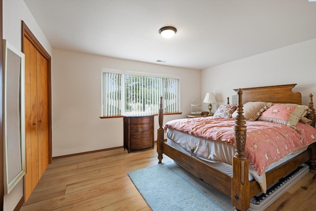 bedroom featuring baseboards, visible vents, and light wood finished floors