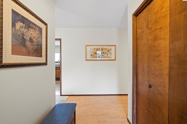 corridor featuring light wood-style floors and baseboards