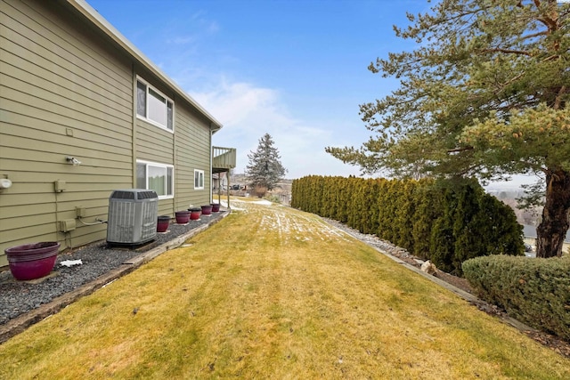 view of yard with central air condition unit and a balcony