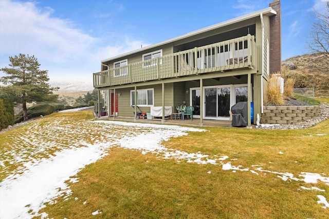 back of house featuring a patio area, a lawn, and a chimney