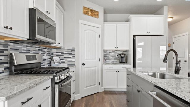 7104 W 31st Pl, Kennewick, WA 99338 - kitchen featuring appliances with stainless steel finishes, dark wood-style floors, decorative backsplash, and white cabinetry