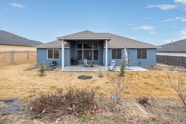 back of house featuring a shingled roof, a fenced backyard, a patio, and a lawn