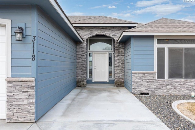 property entrance featuring crawl space, stone siding, and roof with shingles