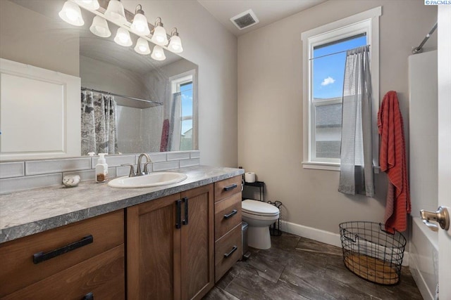 bathroom with curtained shower, a healthy amount of sunlight, visible vents, and toilet