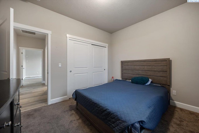 bedroom featuring carpet, a closet, visible vents, and baseboards