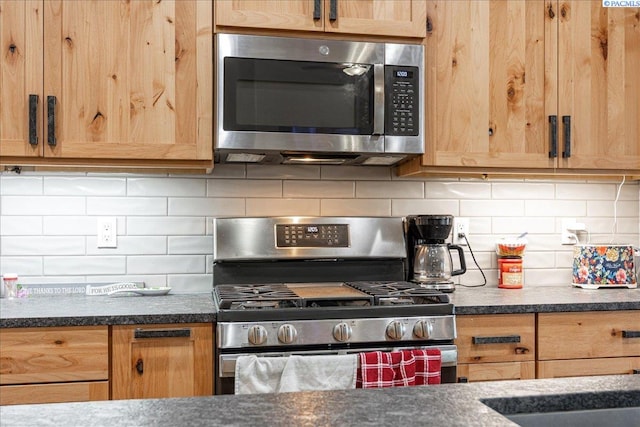 kitchen featuring light brown cabinetry, appliances with stainless steel finishes, and tasteful backsplash