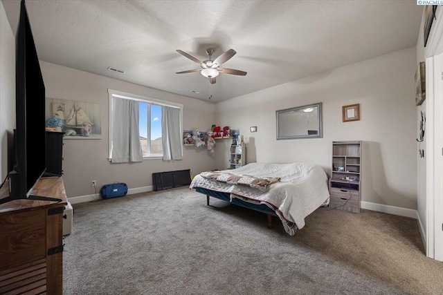 bedroom with carpet floors, a textured ceiling, baseboards, and a ceiling fan