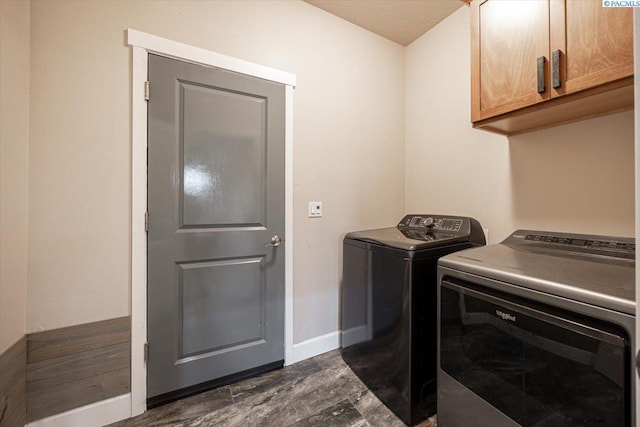 laundry area with dark wood-type flooring, cabinet space, washer and clothes dryer, and baseboards