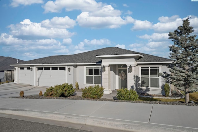 view of front of house featuring a garage, concrete driveway, a shingled roof, and stucco siding