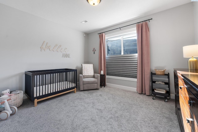 carpeted bedroom featuring a nursery area, baseboards, and visible vents