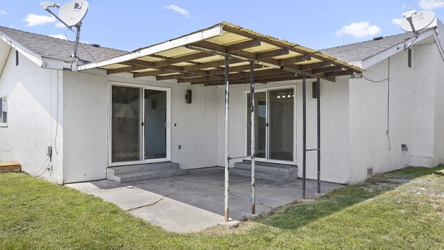 back of house featuring a patio area and a lawn