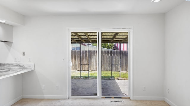 doorway to outside with light colored carpet