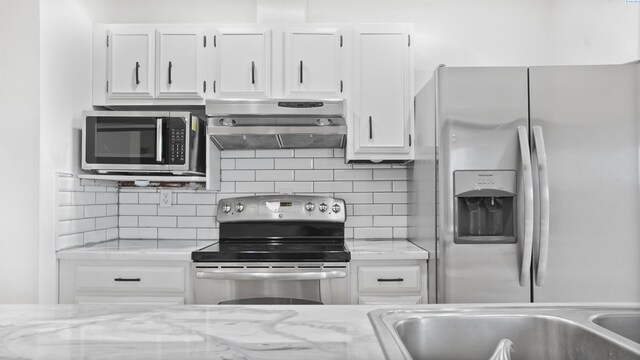 kitchen with light stone countertops, white cabinetry, appliances with stainless steel finishes, and tasteful backsplash