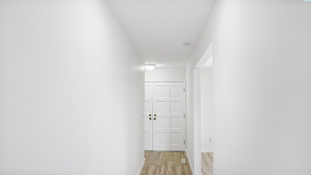 corridor with light hardwood / wood-style floors