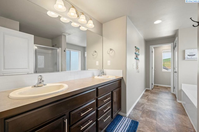 720 SW Wheat Ridge Dr, Pullman, WA 99163 - full bathroom featuring double vanity, a stall shower, baseboards, a garden tub, and stone finish floors