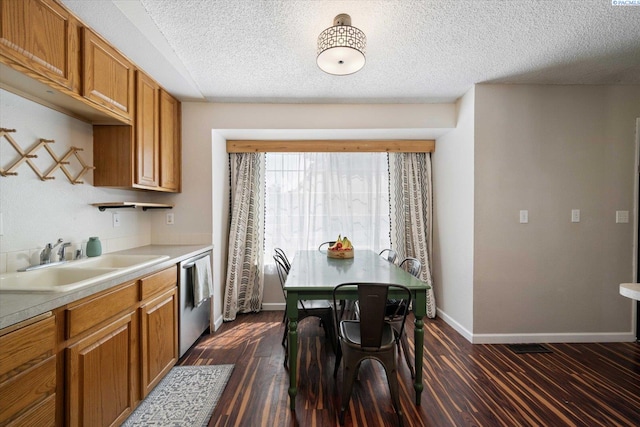 324 S Zinser St, Kennewick, WA 99336 - kitchen with stainless steel dishwasher, brown cabinetry, light countertops, a textured ceiling, and dark wood finished floors