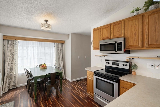 324 S Zinser St, Kennewick, WA 99336 - kitchen featuring stainless steel appliances, a textured ceiling, light countertops, dark wood-type flooring, and brown cabinetry