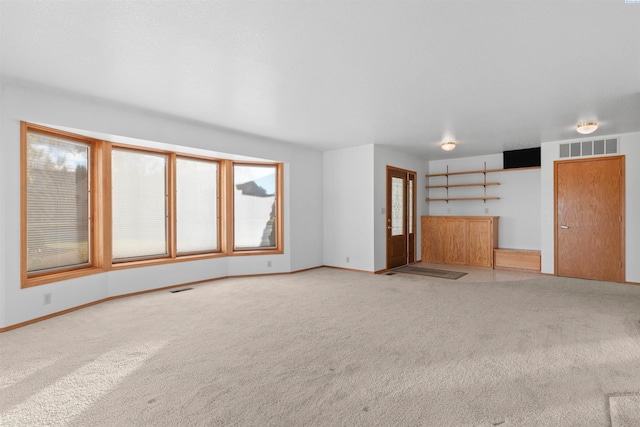 unfurnished living room featuring carpet