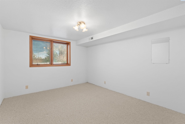 carpeted spare room with a textured ceiling