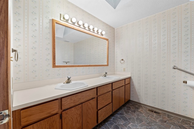 bathroom featuring vanity, a skylight, and a textured ceiling