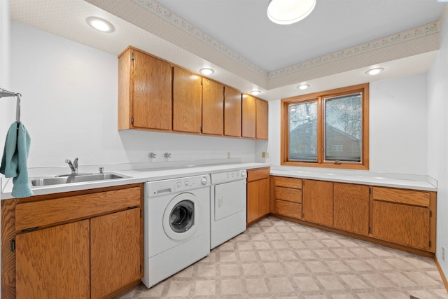 laundry room featuring cabinets, sink, and washer and clothes dryer