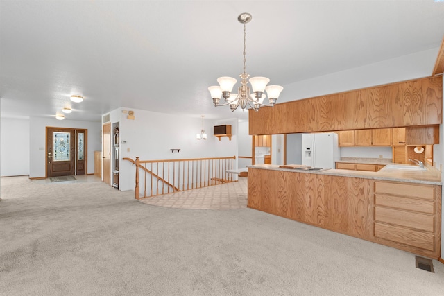 kitchen featuring pendant lighting, sink, an inviting chandelier, white fridge with ice dispenser, and light carpet