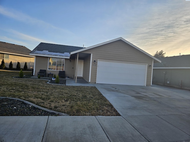 ranch-style house featuring a yard and a garage