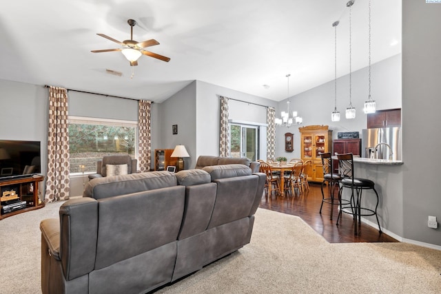 living room featuring high vaulted ceiling, dark hardwood / wood-style flooring, and ceiling fan with notable chandelier