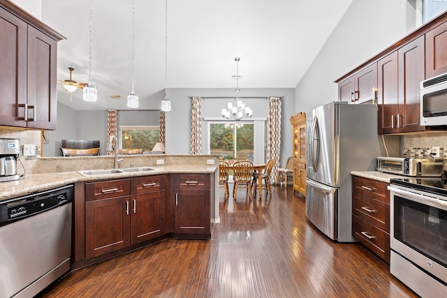 kitchen featuring lofted ceiling, sink, tasteful backsplash, hanging light fixtures, and stainless steel appliances