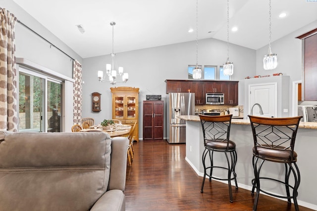 kitchen featuring pendant lighting, appliances with stainless steel finishes, dark hardwood / wood-style flooring, and dark brown cabinets