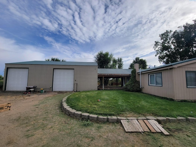 exterior space featuring a garage, an outdoor structure, and a lawn