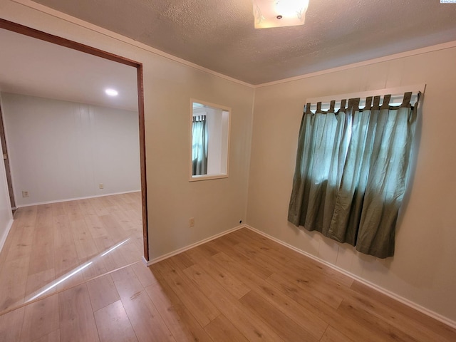 spare room with a textured ceiling and light wood-type flooring