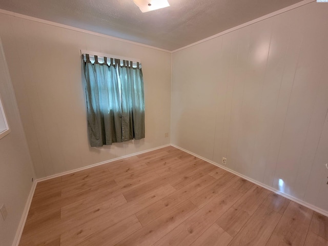 spare room with a textured ceiling and light hardwood / wood-style flooring