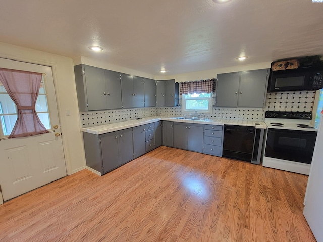 kitchen featuring gray cabinets, sink, light hardwood / wood-style flooring, and black appliances