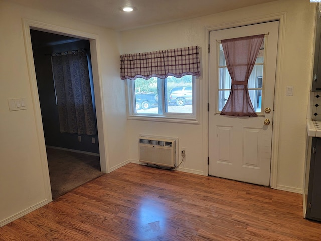 entryway with wood-type flooring and a wall unit AC